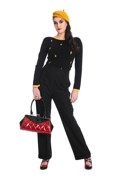 Vintage-inspired handbag made of black and red vinyl with red quilted body and black sides & top with matching black handles. Purse has silver metal kiss lock opening and matching detachable shoulder strap. Shown held by model