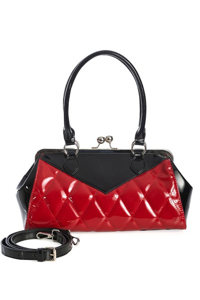 Vintage-inspired handbag made of black and red vinyl with red quilted body and black sides & top with matching black handles. Purse has silver metal kiss lock opening and matching detachable shoulder strap. Shown from front with shoulder strap