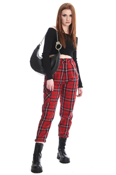 Black faux leather crescent shaped slouchy shoulder bag with silver metal handcuff chain strap and matching silver chain running across the bottom of the bag. Shown held by model