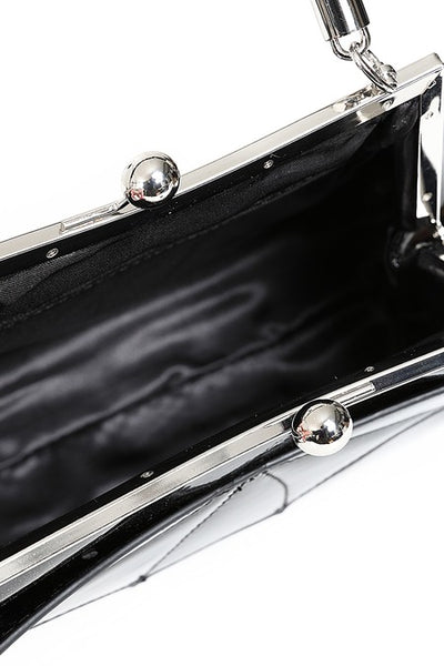 A black patent vinyl with shimmery silver handbag with a glossy finish, featuring a bat-wing design on the front, a top handle, and a silver-tone kiss-lock clasp. Shown open from top to display black satiny lining