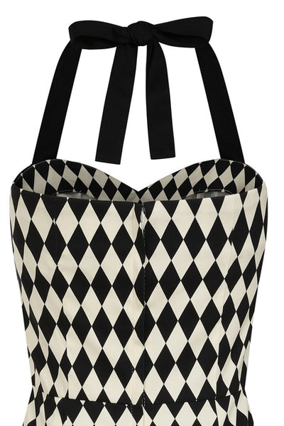 Halter style wiggle dress in black and white harlequin printed cotton sateen with sweetheart neckline, contrasting black black trim at the bodice with black halter straps and princess seaming with pencil length skirt. Shown from back in close up of bodice