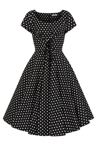 cotton fit and flare style short sleeve dress in a crisp black and white polka dot pattern, featuring a scoop neckline and fitted bodice with underbust lacing, and a full knee length skirt
