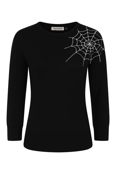 black crewneck knit sweater with ribbed neckline, bottom band, and cuffs with bright white embroidered spiderweb detail at left shoulder extending to neckline. Shown from front