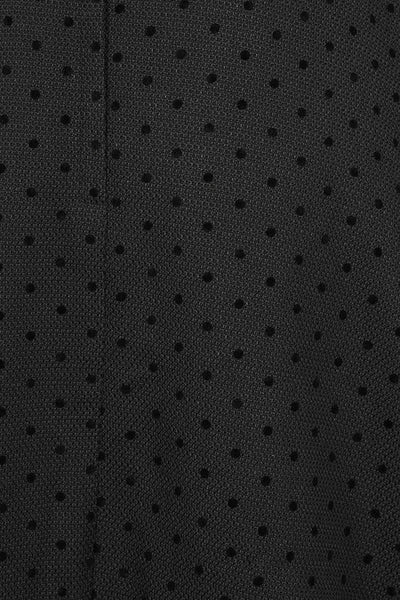 black high-waisted circle swing skirt with side seam pockets in textured woven fabric with all over pattern of flocked small polka dots. Shown from front in close up of pattern texture