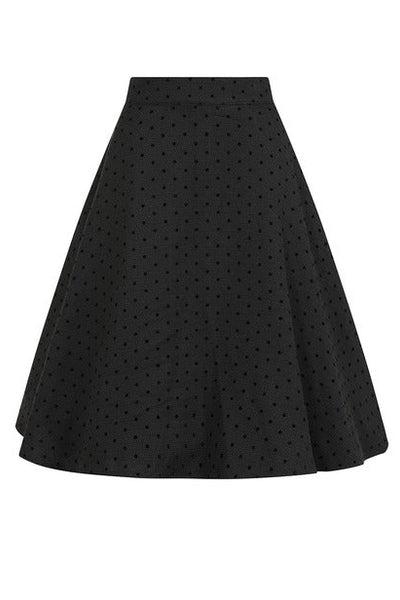black high-waisted circle swing skirt with side seam pockets in textured woven fabric with all over pattern of flocked small polka dots. Shown from front