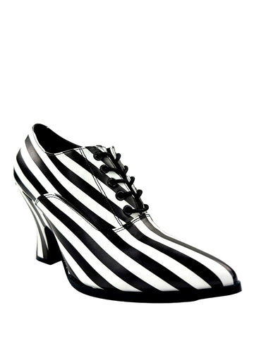 Black and white striped faux leather heels with lace up detail, an exaggerated curved heel, and rounded pointed toes. Shown from a three quarter angle