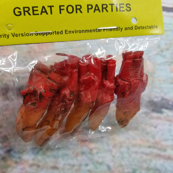 Set of rubber severed fingers painted to look dirty and bloody shown in plastic packaging. Shown in close up
