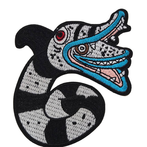 Embroidered patch of a sandworm from Beetlejuice with a colorful mouth on a white background