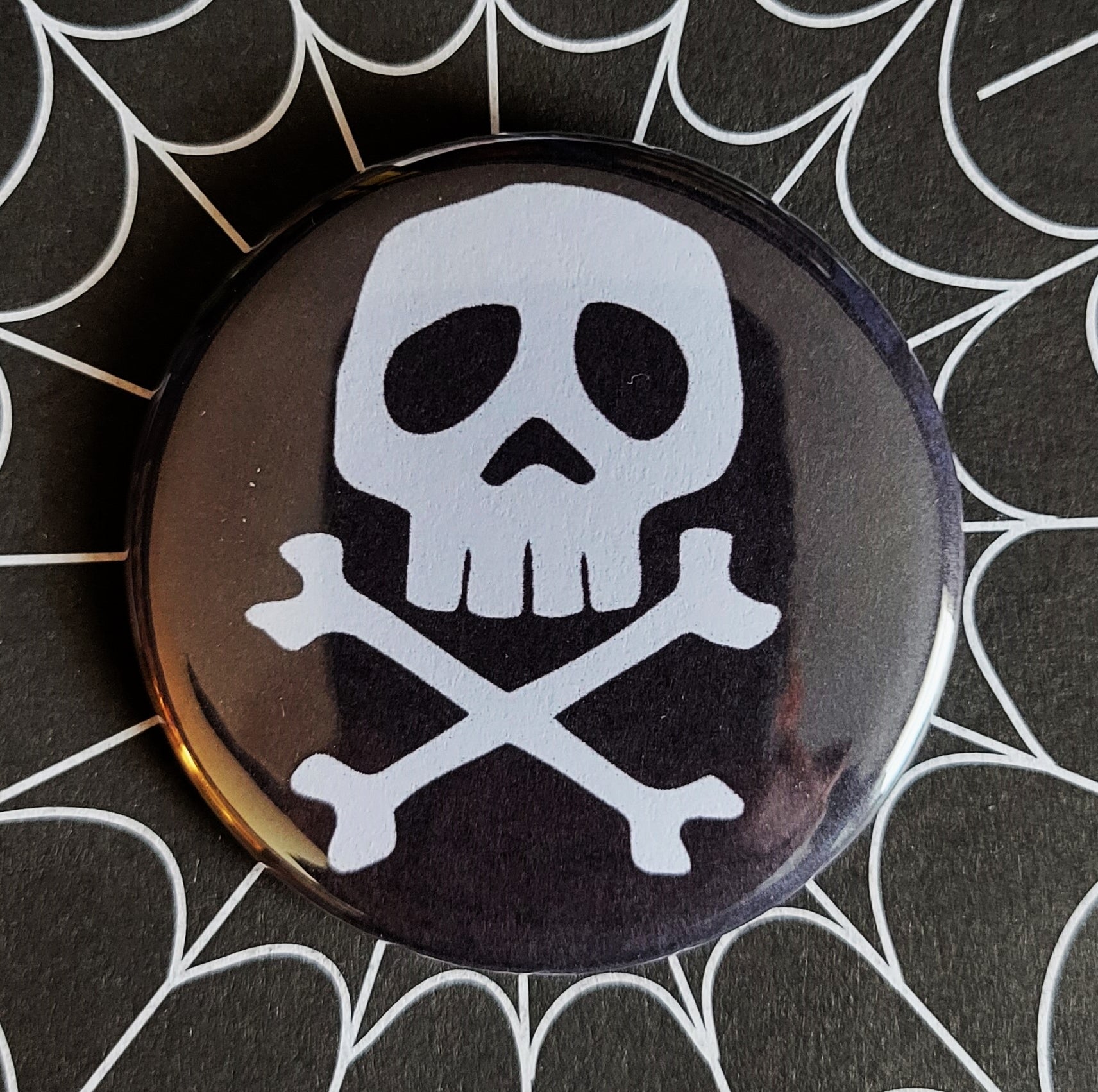 1.25” Captain Harlock skull and crossbones illustration in white on black background pinback