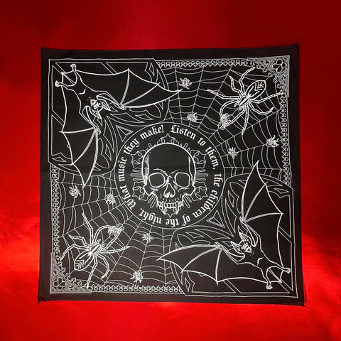 Square black cotton bandana with screen printed white image of mirrored bats and spiders inside a web with center image of vampire skull with quote “ Listen to them, the children of the night. What music they make!”. Shown flat on red background 