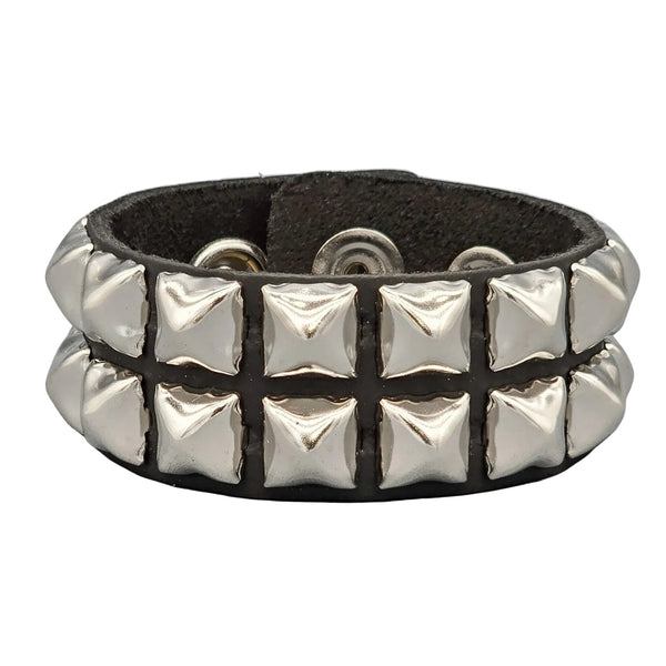A 1 1/4” black leather cuff with two rows of 1/2” silver pyramid studs and double snap closure. Shown from front