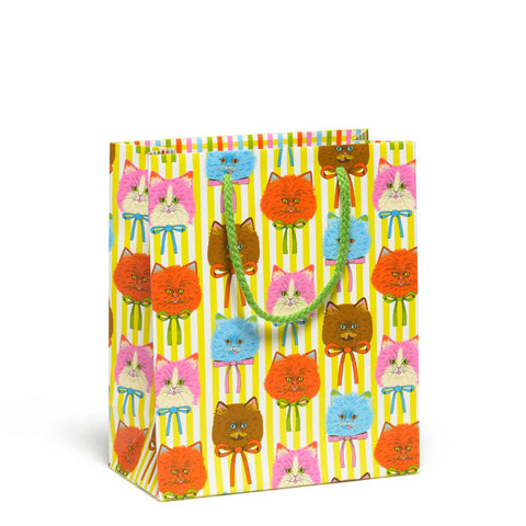 Rectangular gift bag with allover print of pink, blue, orange, and brown longhairs cats with orange, green, pink, and blue bows around their necks on a white and yellow vertically striped background. Has bright green cotton handles