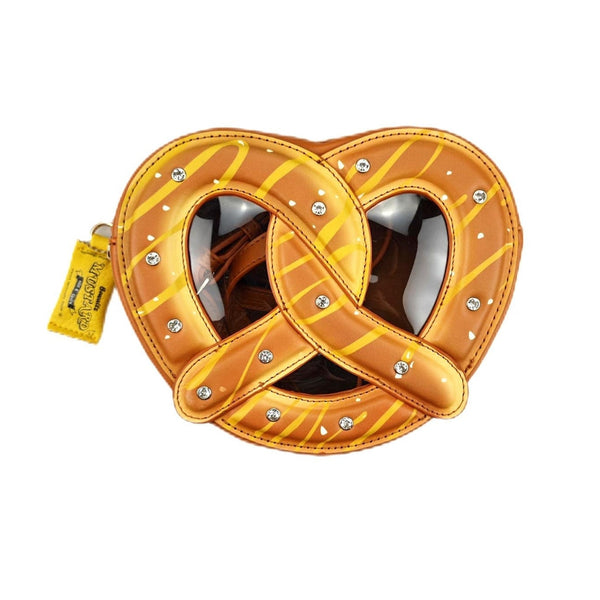 A crossbody purse in the shape of a large pretzel with mustard packet-shaped zipper pull, large rhinestones as grains of salt, and brown vinyl window. Shown from front