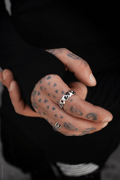 model wearing black long sleeve crew neck shirt with thumb holes. Shown from front in close up of thumb hole detail
