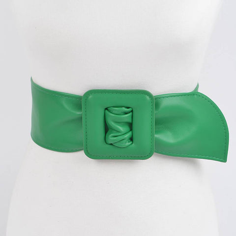 kelly green matte finish faux leather belt with a large square self buckle on dress form on a white background