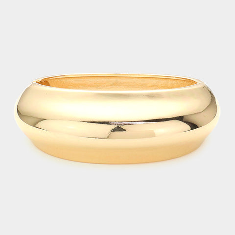 shiny gold metal rounded hinged bangle. Shown from side