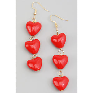 Dangle earrings of three red acrylic puffy hearts connected to each other