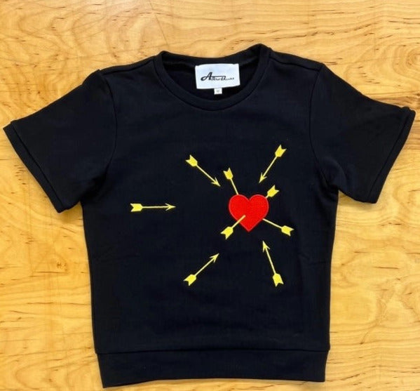 cropped length thick black cotton short sleeve raglan pullover top featuring an embroidered bold red heart under attack from many bright yellow arrows, shown flatlay