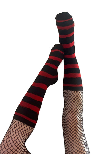 Pair of unisex black and red distressed style striped socks shown worn by model wearing over fishnets