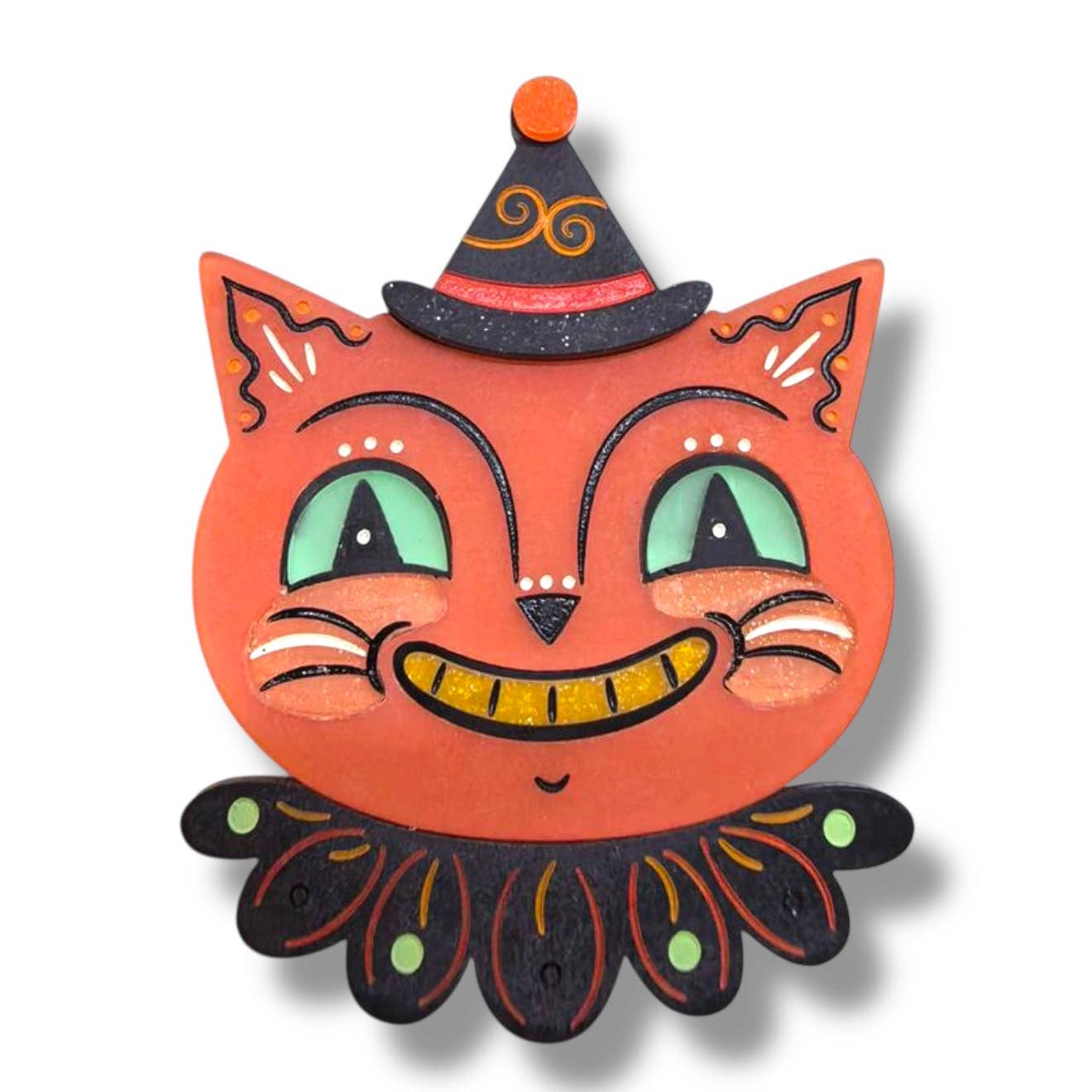 layered acrylic resin brooch of orange cat with black ruffled collar and witchy clown hat with orange pom pom