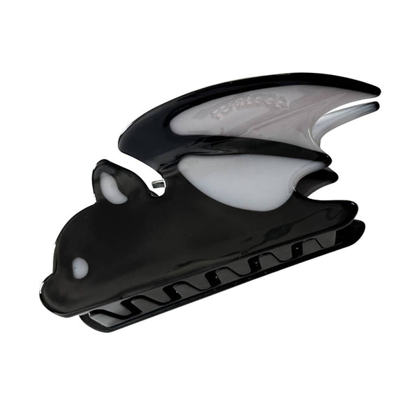 black claw-style hair clip in the shape of a bat with grey eyes, ear, and details of wing. Shown flat