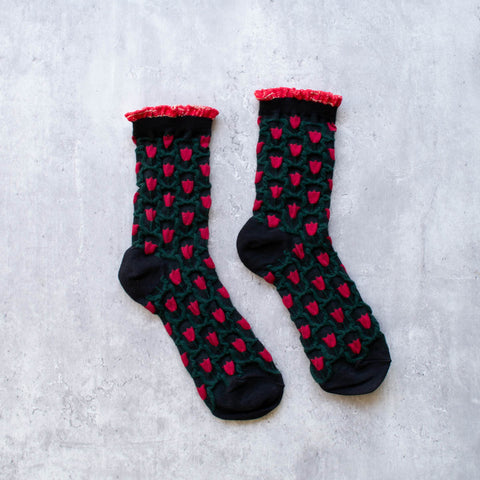 cotton knit socks in black with an allover red and green tulip knit-in pattern and a red and gold lurex ruffled cuff
