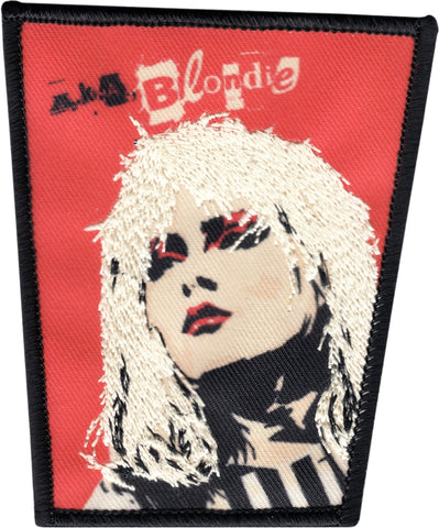 trapezoid shaped red embroidered patch with black border featuring image of Debbie Harry with platinum stitched hair detail and "A.K.A. Blondie"