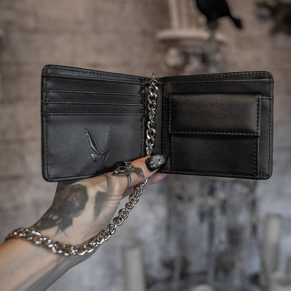 Black faux leather billfold style Waller with grey art of haunted house on exterior and wallet chain. Shown open to display card slots and coin purse