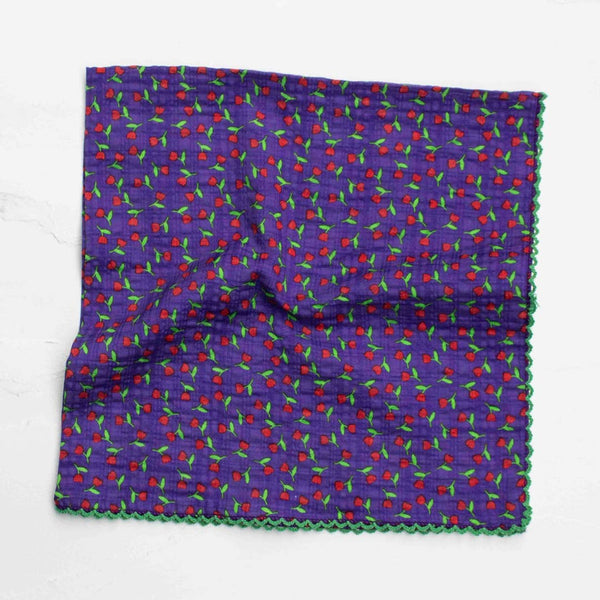 cotton seersucker square scarf in purple background ditsy red and green rosebud print with bright green scalloped embroidered trim. Shown folded