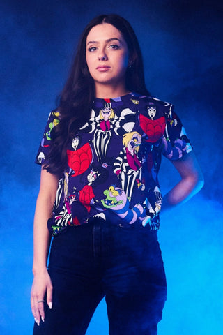 female model wearing cotton t-shirt with all-over print of purple background and images of characters from Beetlejuice cartoon. Shown from front