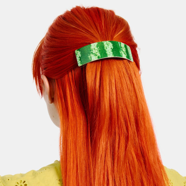 curved acetate pinch clip style barrette with photorealistic watermelon rind design. Shown worn in model's hair
