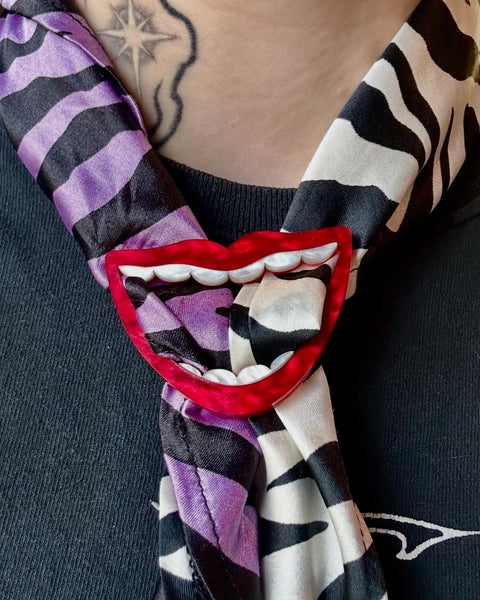 layered acrylic pearly white and red big mouth shaped scarf slide shown worn with zebra print silk scarf