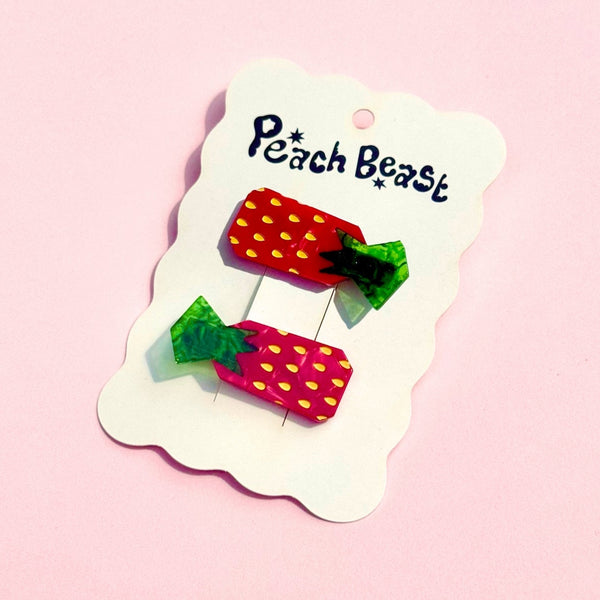 set of two plant-based acetate marbled red and green strawberry candy shaped hair clips on a backing card