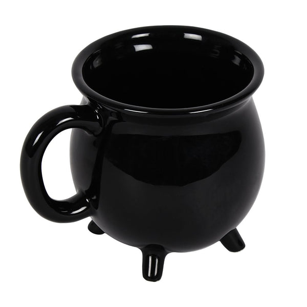 Black shiny glazed ceramic mug in the shape of a cauldron with four small feet at the bottom. Shown from the top
