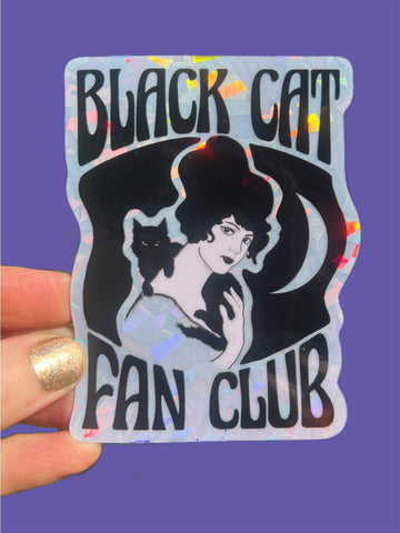 holographic die cut sticker with 'Black Cat Fan Club' design and image of woman with black cat on her shoulders held by a hand on a purple background