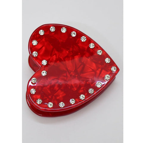 a red acetate heart-shaped claw clip with a border of clear rhinestone style jewels