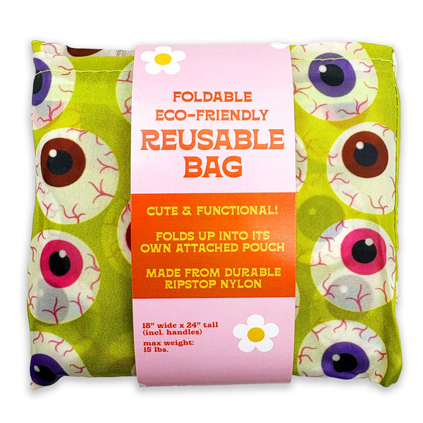 Foldable reusable bag in a lime green fabric with a cartoon eyeball pattern, wrapped in a pink paper band label that reads 'FOLDABLE ECO-FRIENDLY REUSABLE BAG'.