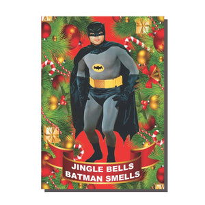 Rectangular note card with a digital collage of candy canes, ornaments, and pine tree branches with an image of Adam West as Batman and the message “JINGLE BELLS BATMAN SMELLS” underneath 