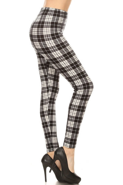 High-waist leggings in a black and cream plaid print. Shown on a model from a side angle