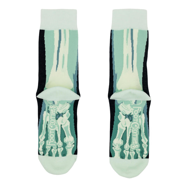 A pair of unisex cotton blend crew socks with a light blue and white x-ray style skeleton foot design, shown from the back