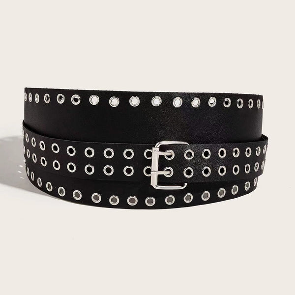 asymmetrical faux black leather waist belt with two pieces- a wide piece of black faux leather with a border of silver metal eyelets and a smaller piece wrapped around it with a double row of eyelets and double pronged buckle. Shown flat