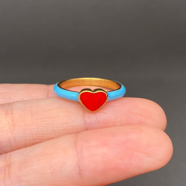 18k gold plated stainless steel ring with thin enameled bright blue band and red heart face. Shown held in hand