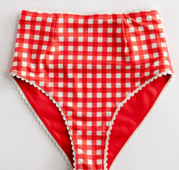 red and white gingham print reversible high waisted bikini bottoms with white rickrack style trim. Shown flat with gingham side shown