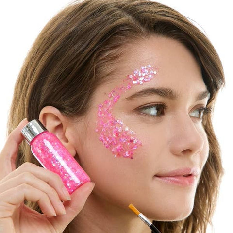 Woman applying pink decorative glitter makeup with a brush on a white background