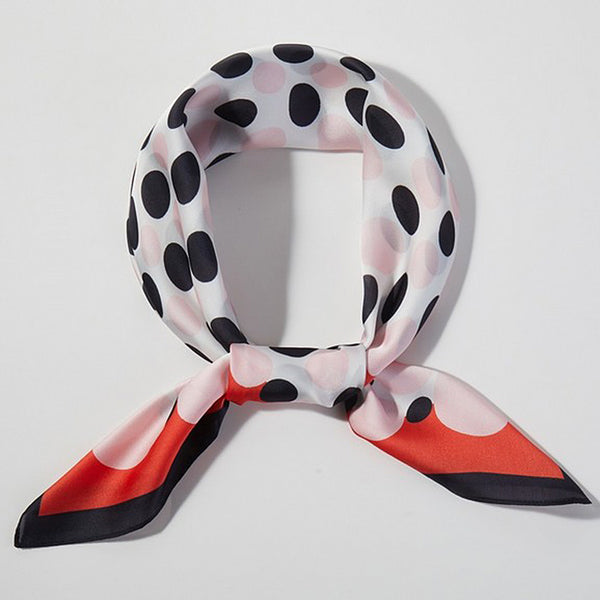 square silk scarf with white background and black & very light pink dot center and red and black border. Shown tied in loop