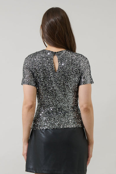 model wearing black short sleeve top with round neckline, black background and allover silver sequin adornment with keyhole back. Shown from back