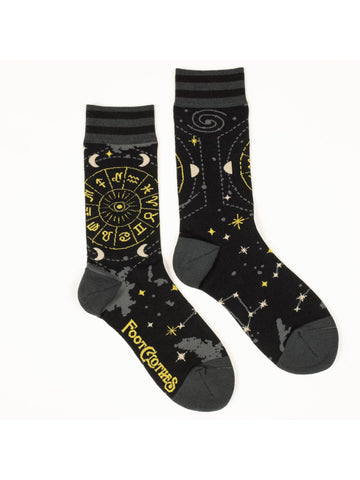 Unisex crew socks with a yellow Astrology wheel illustration on the outer side of each sock and constellations, stars, moons, and clouds in grey/white/gold lurex thread as an all over pattern on a black background. Shown flat