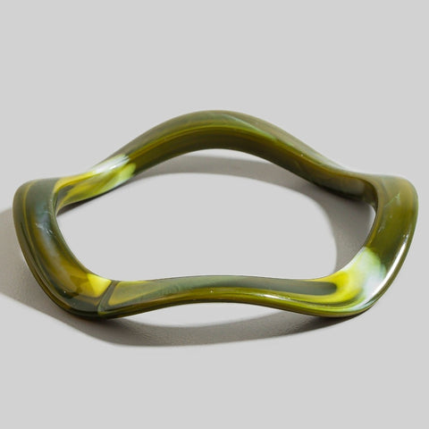 wavy shaped resin bangle in shade of dark olive green with white and yellow-y green marbling