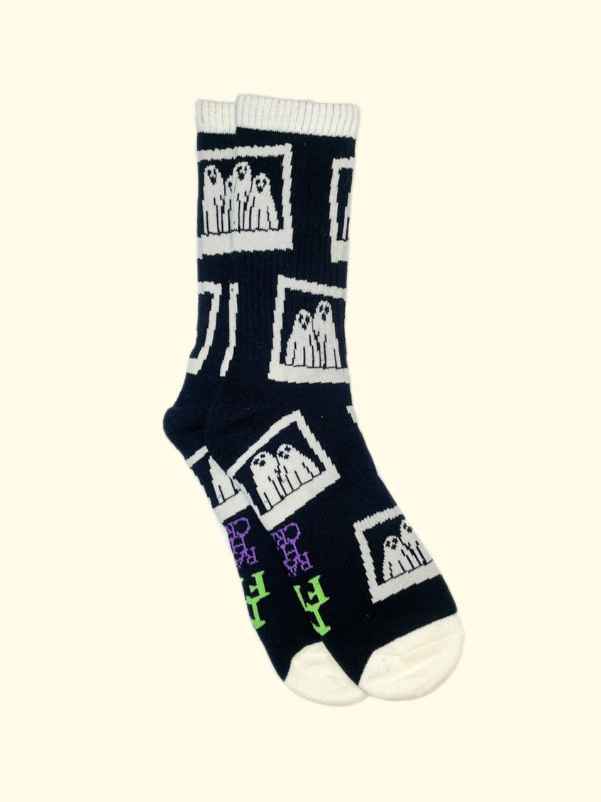 black cotton unisex crew socks with an all-over print of instant film camera pictures of a pair of ghosts wearing sheets