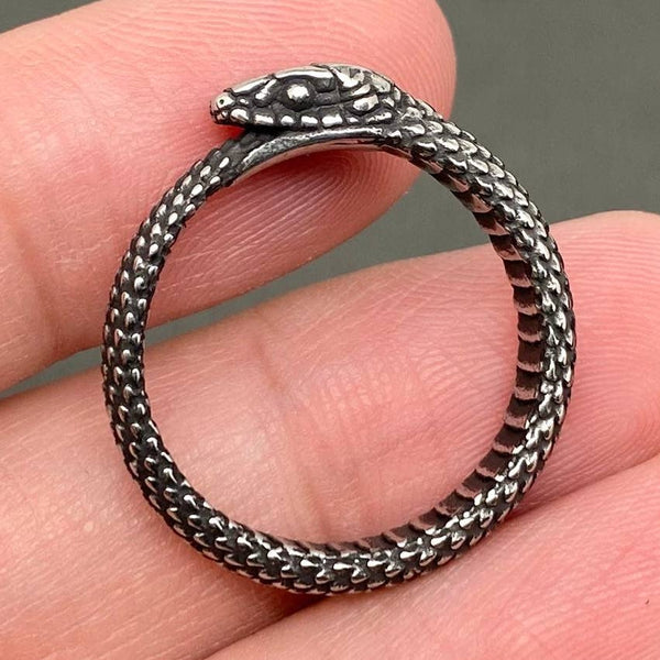 antiqued finish stainless steel ring in the shape of an Ouroboros snake eating its own tail. Shown flat